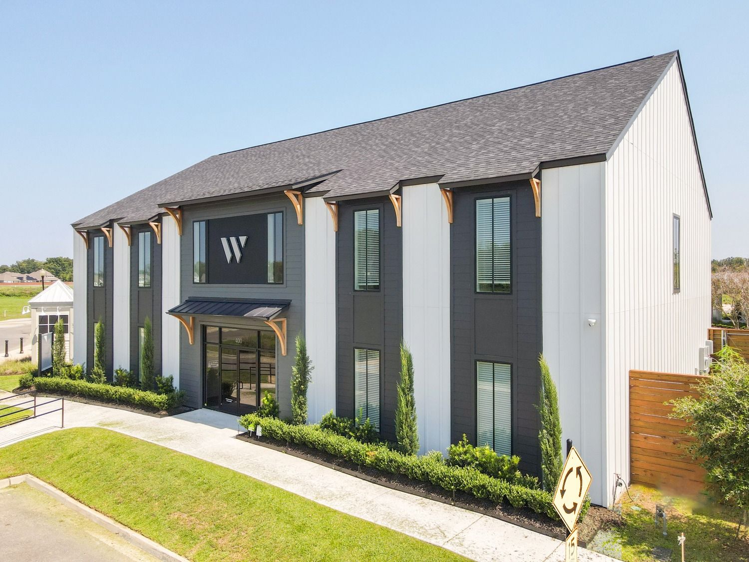 The W Office Suites, Gonzales, LA The W Office Suites in Gonzales, Louisiana: a two-story charcoal and white office building with the W logo above the glass entrance